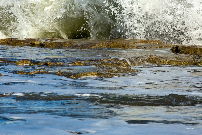 photo of wave breaking on rocks.