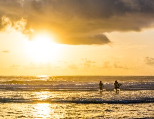 photo of Sufers entering water at Sunrise
