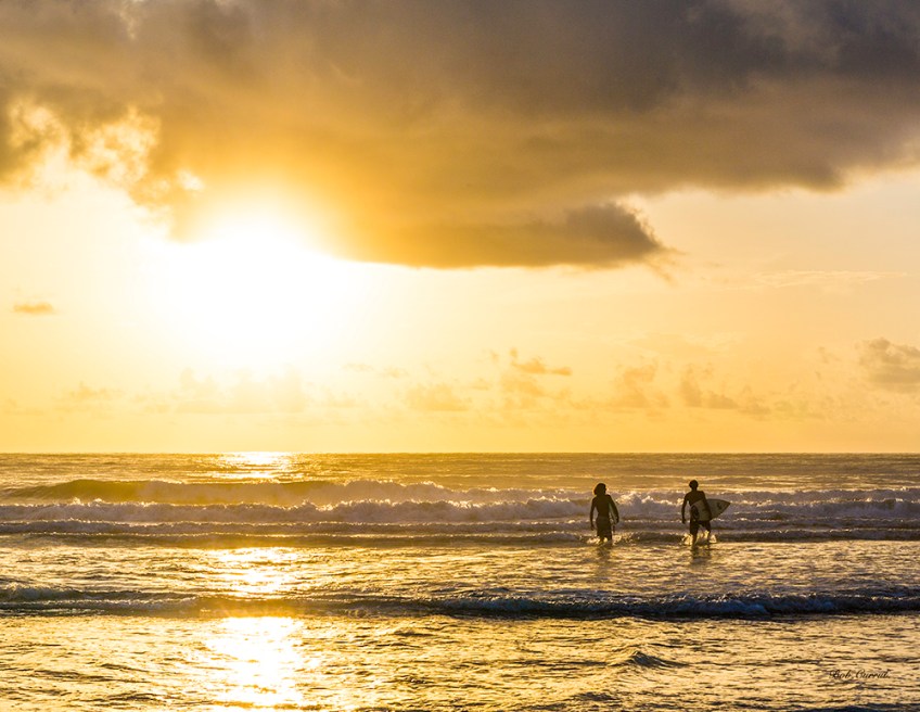 photo of Sufers entering water at Sunrise
